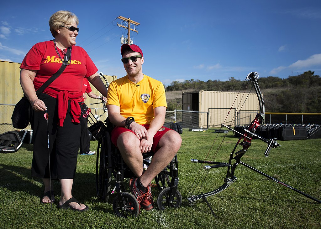 Image showing a woman standing next to a man in a wheelchair