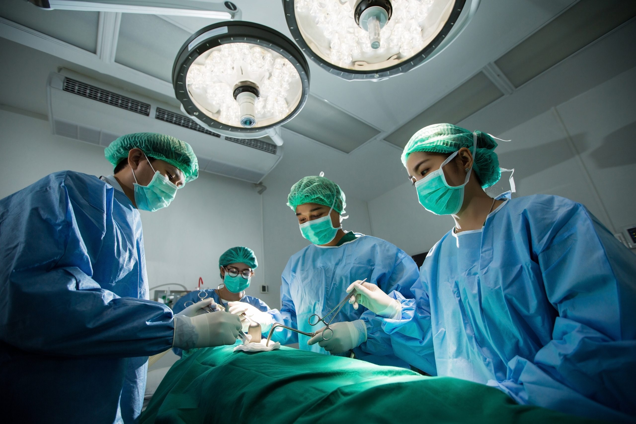 Image showing masked medical team surrounding a patient in a surgical theater