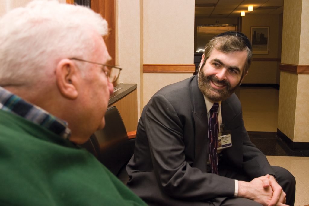Image showing a chaplain speaking to an elderly man