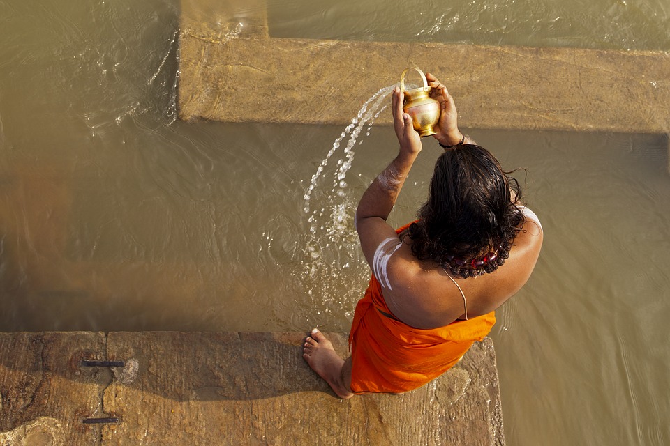 Image showing a persona pouring water into a larger body of water, as in Worship with Water