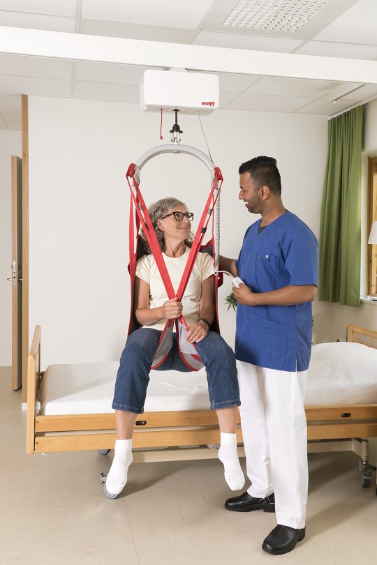 Image showing nurse assisting simulated patient in mechanical lift