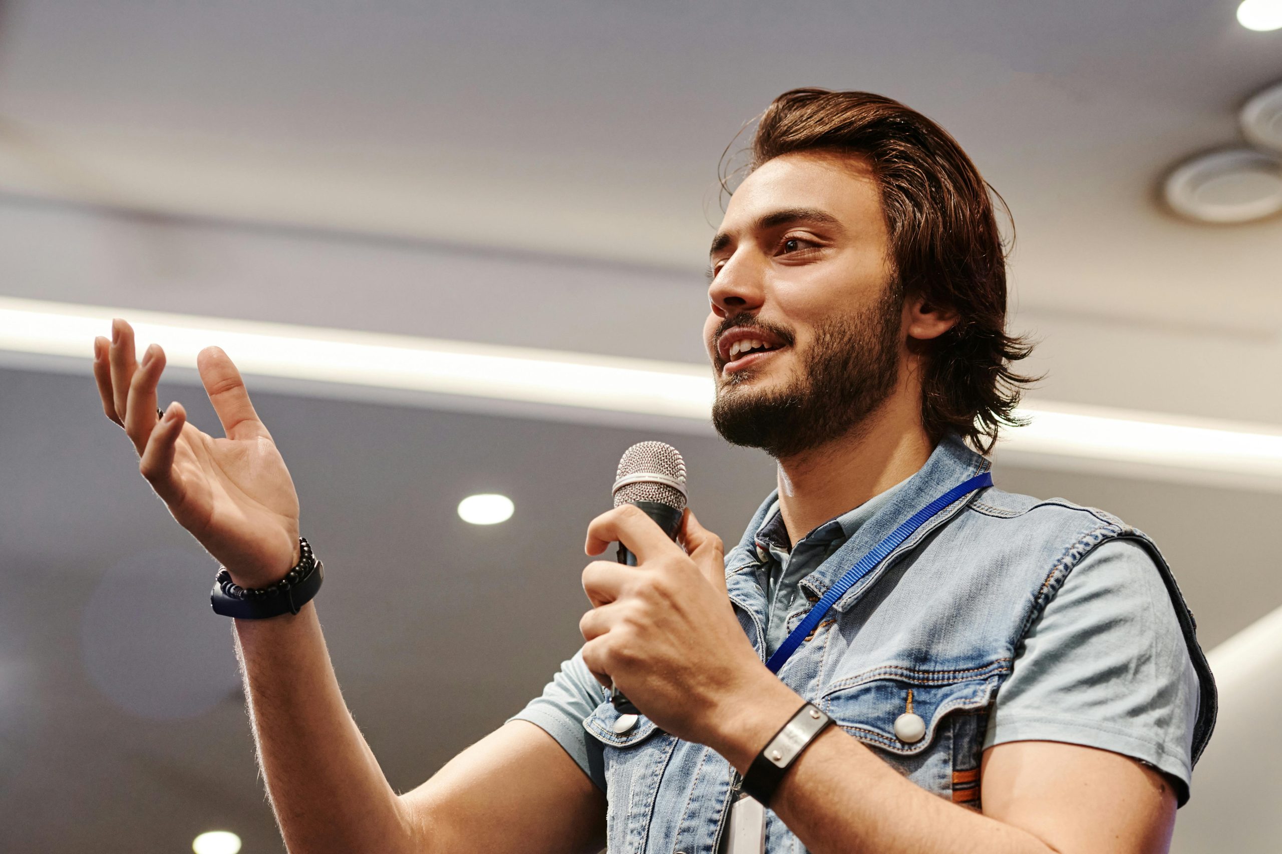 photo of a man speaking into a microphone and smiling