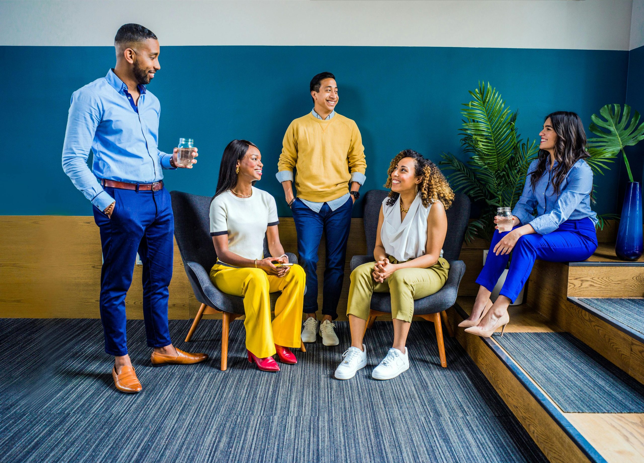 five people sitting by stairs having a conversation