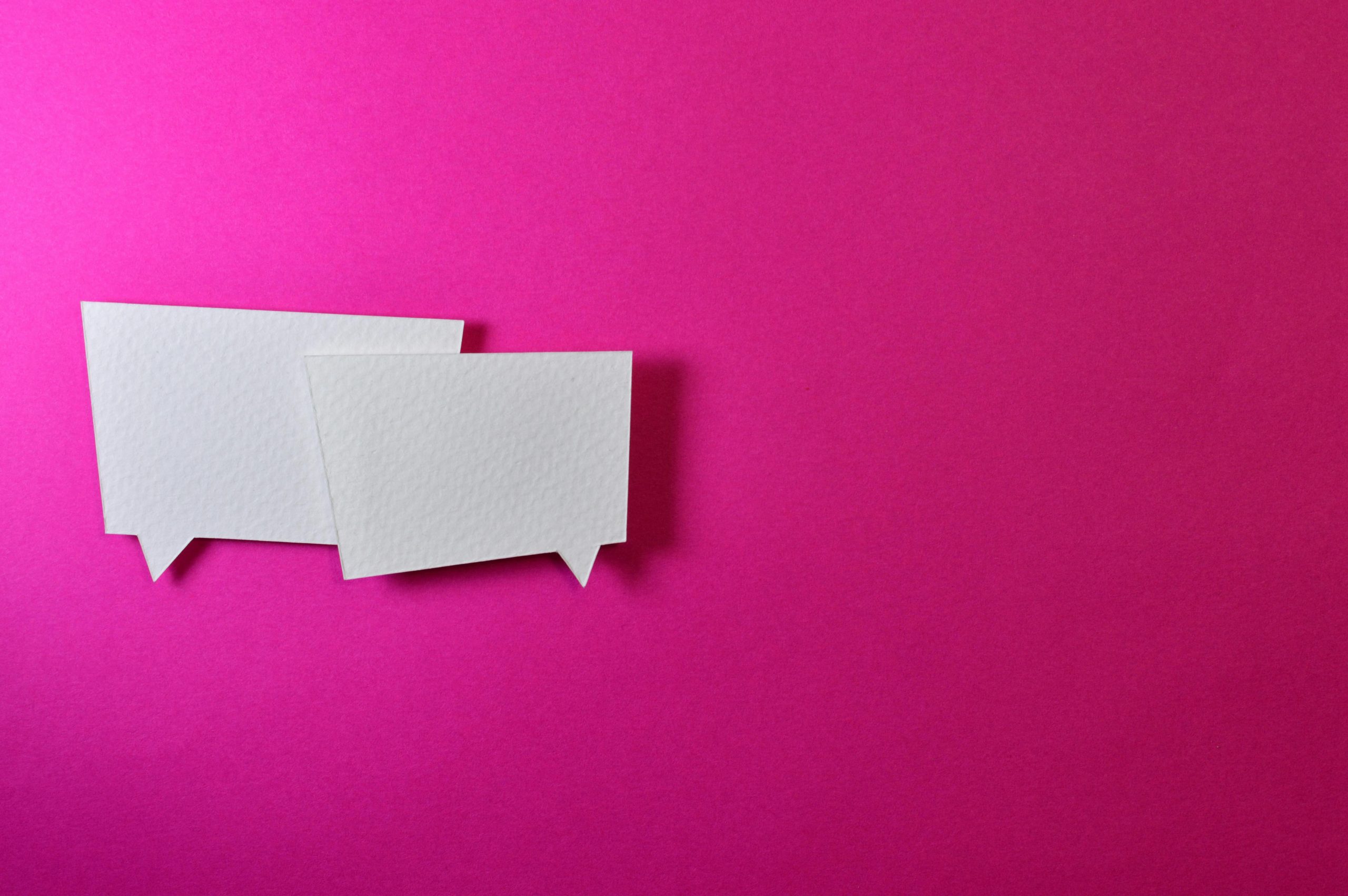 two speech bubbles in white on a pink background