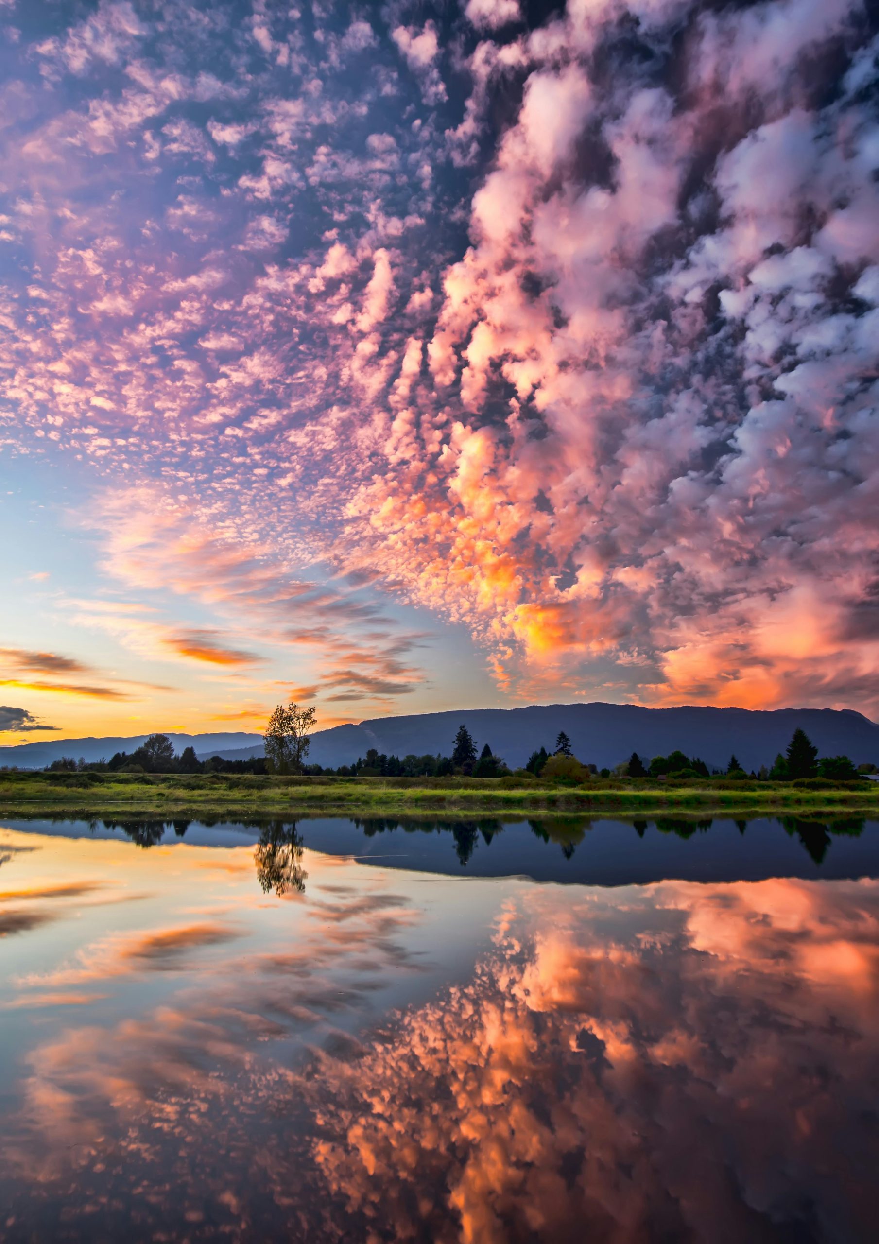 photo of a lake with clouds at sunset