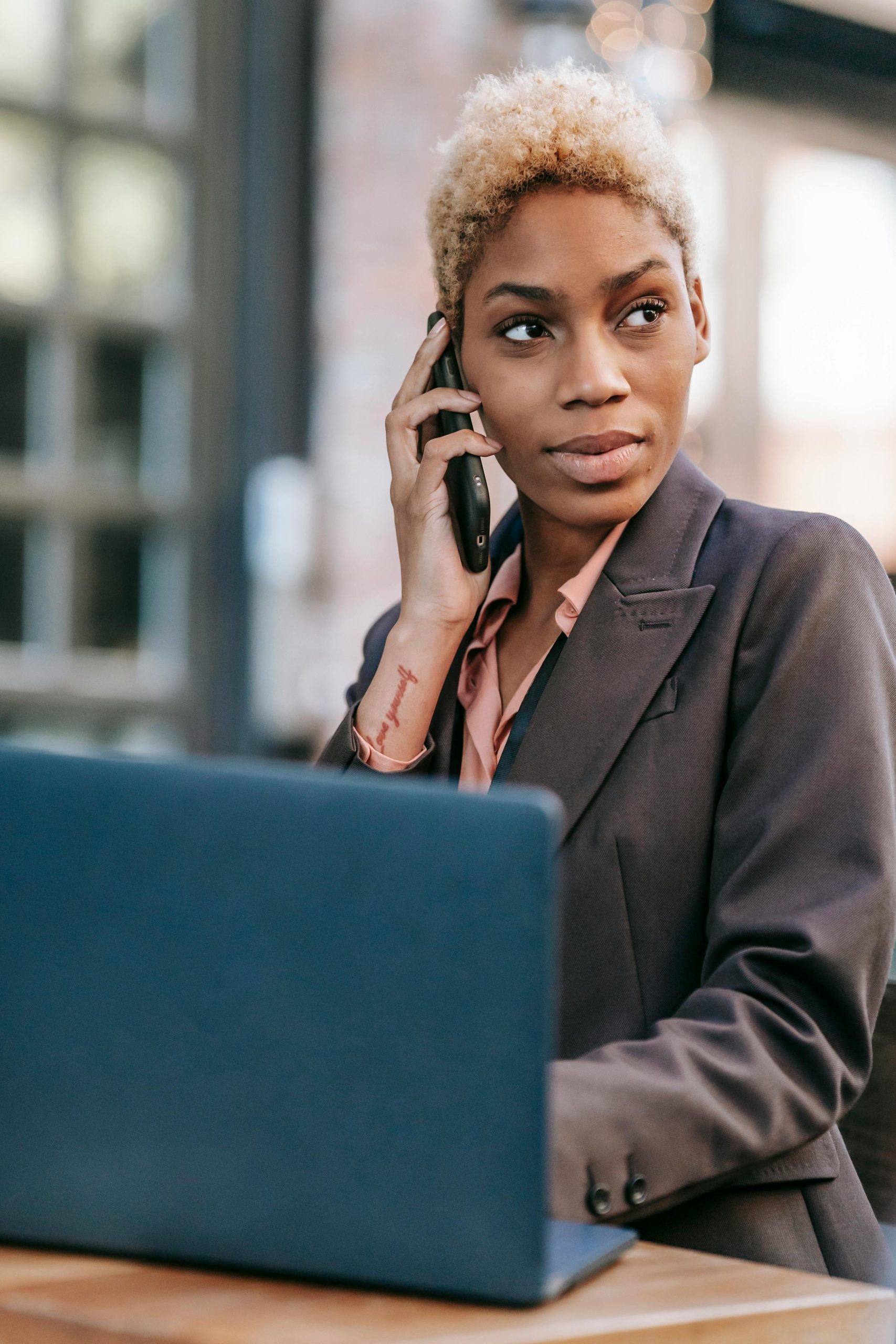 photo of a woman on a phone with a laptop