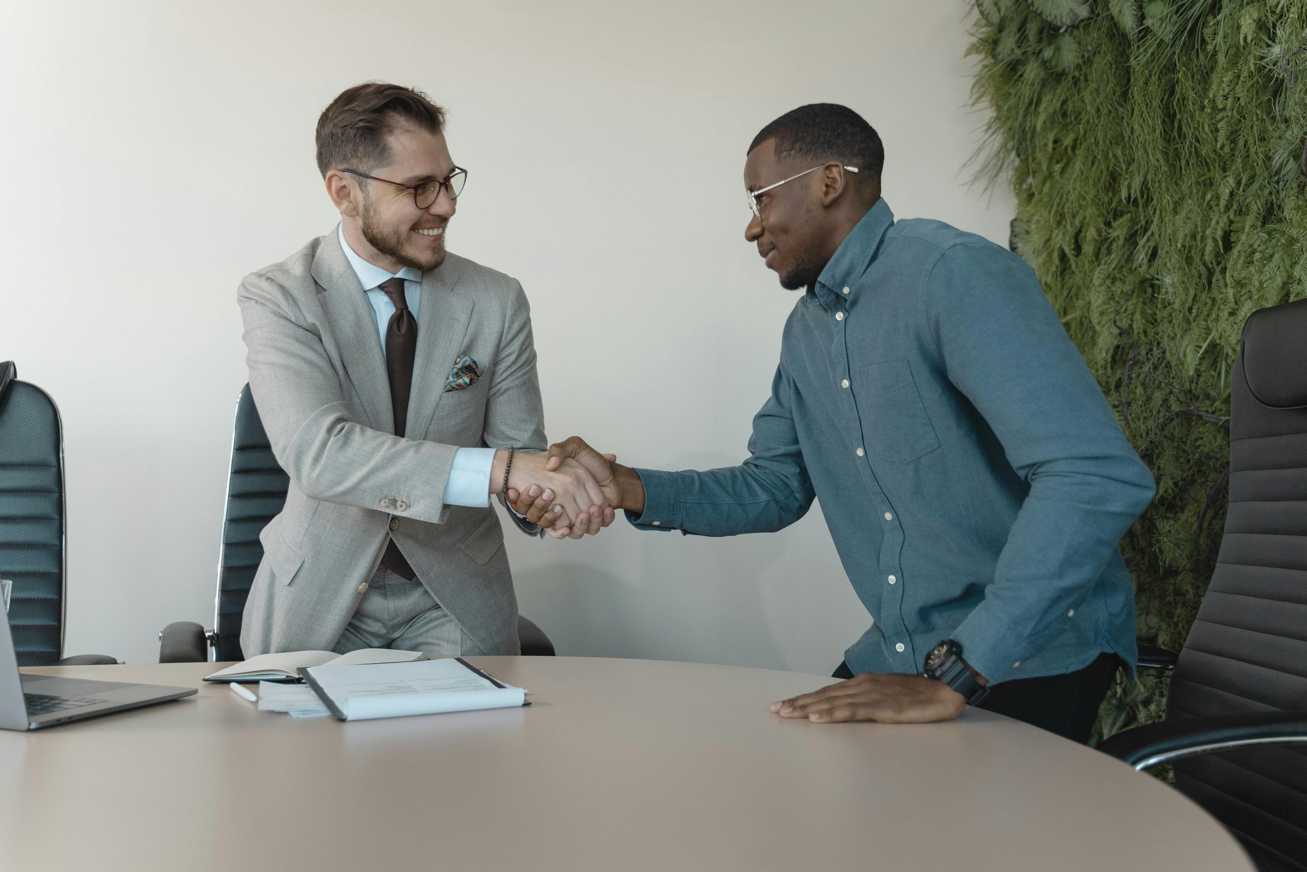 picture of two men shaking hands with some papers on the table