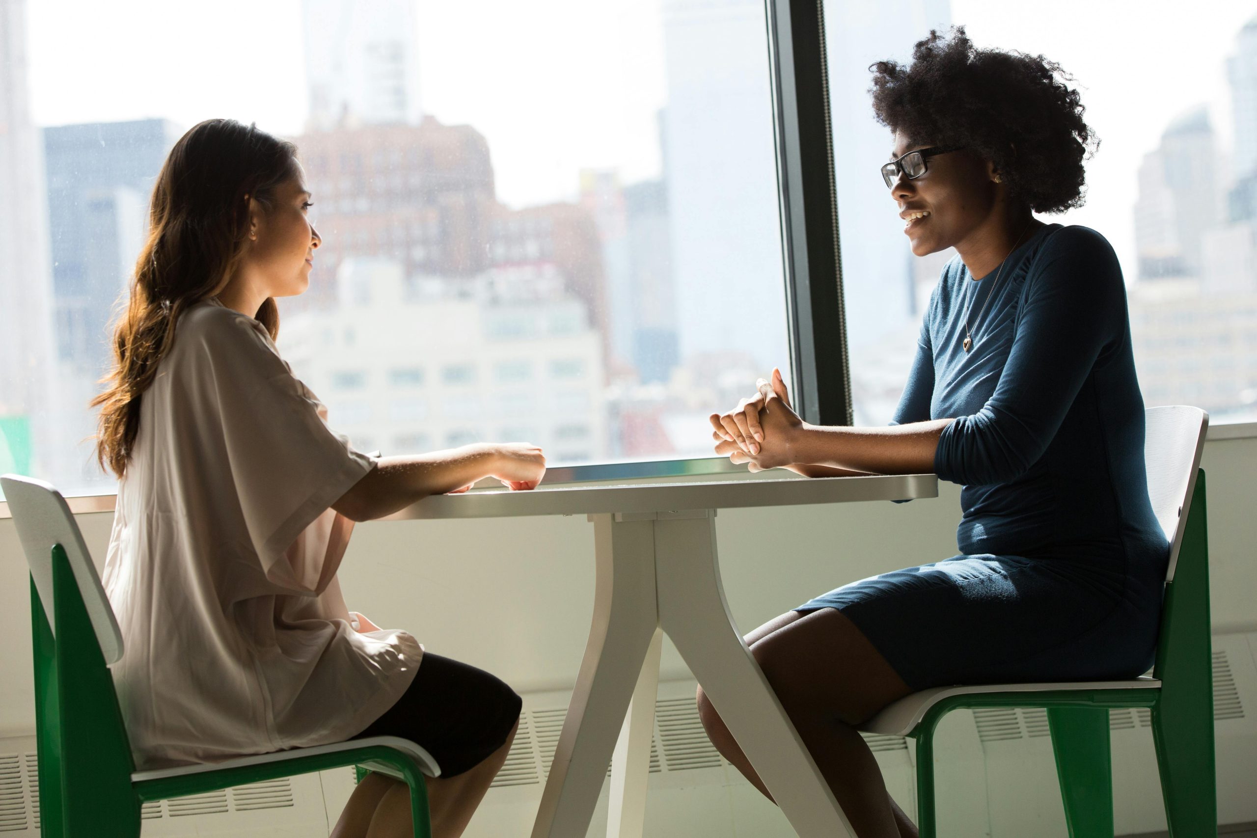 photo of two women speaking at a table